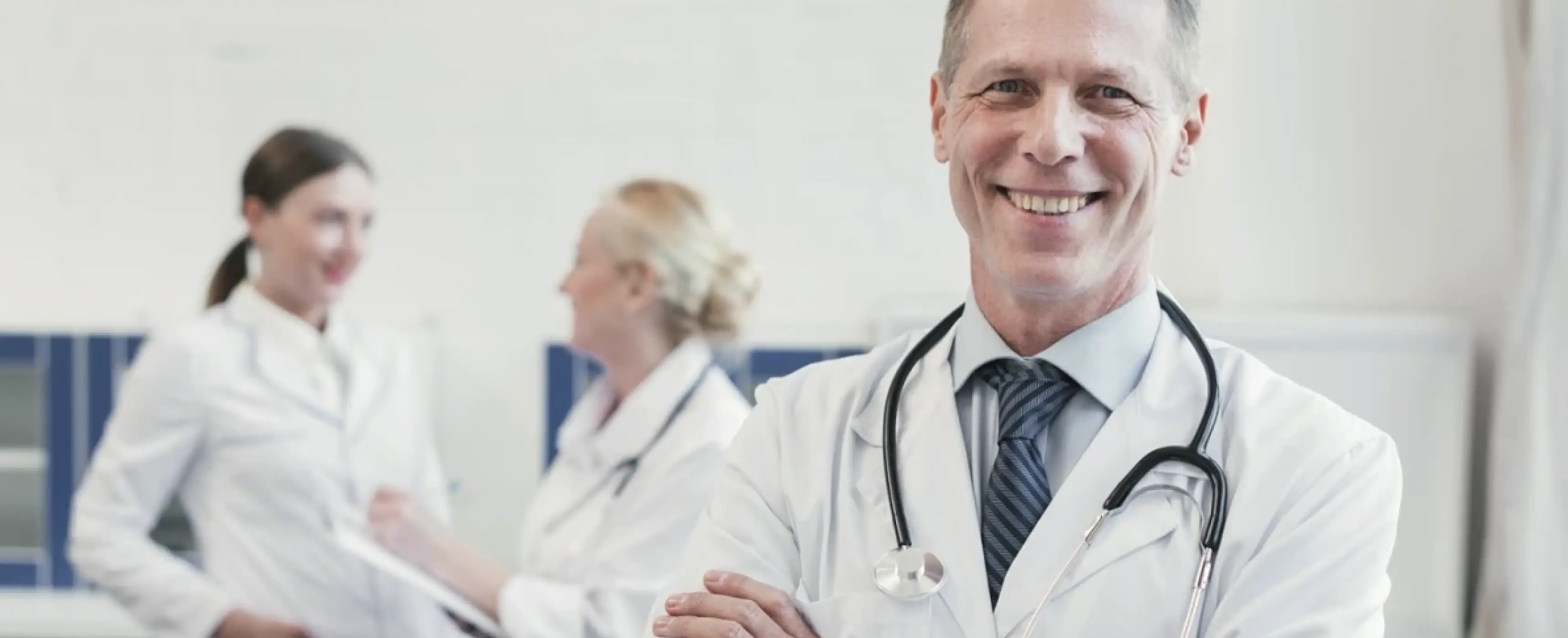 A friendly male provider smiles as he stands before a gathering of people, embodying care and expertise in his field.