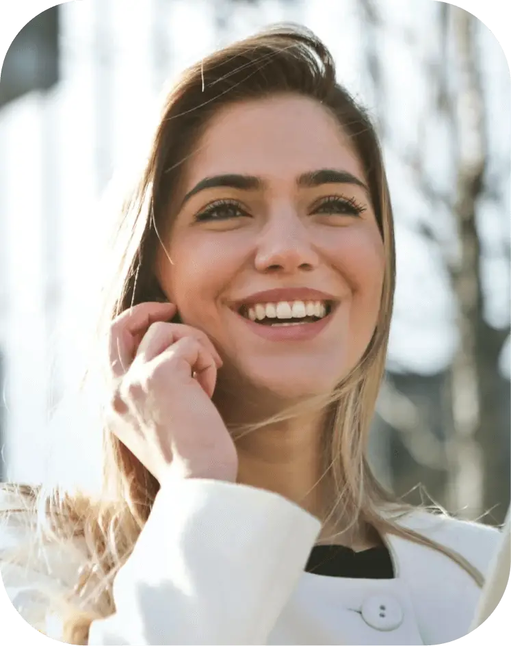 A woman smiles while holding a tablet computer, showcasing a positive and engaging expression.